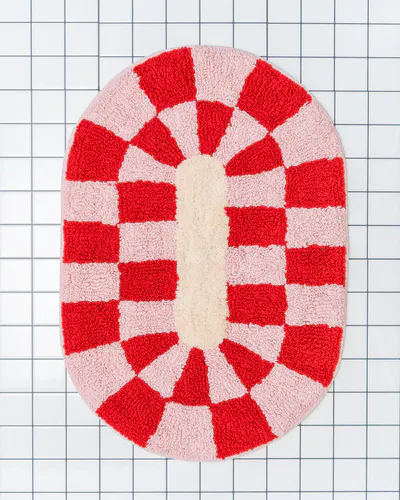 Myk baderomsmatte med ovalt design og rødt–rosa mønster. Rita løfter badet med farge, form og personlighet.